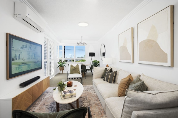 Relax in this stylish living room with a flat-screen TV, comfortable sofa, and dining area.