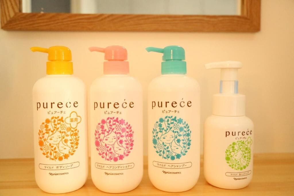 Four bottles of Purece baby formula arranged on a wooden surface.