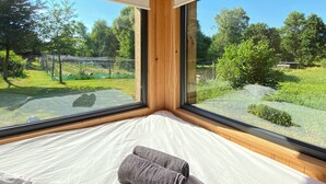 A bedroom with a large window, wooden ceiling, and a neatly made bed. - Lescargoterie de la Forge - Immersion Champêtre (Uzemain)