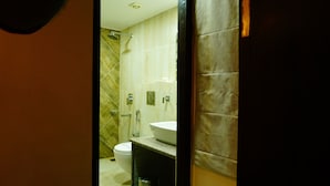 Casa de banho com sanita, lavatório e chuveiro.