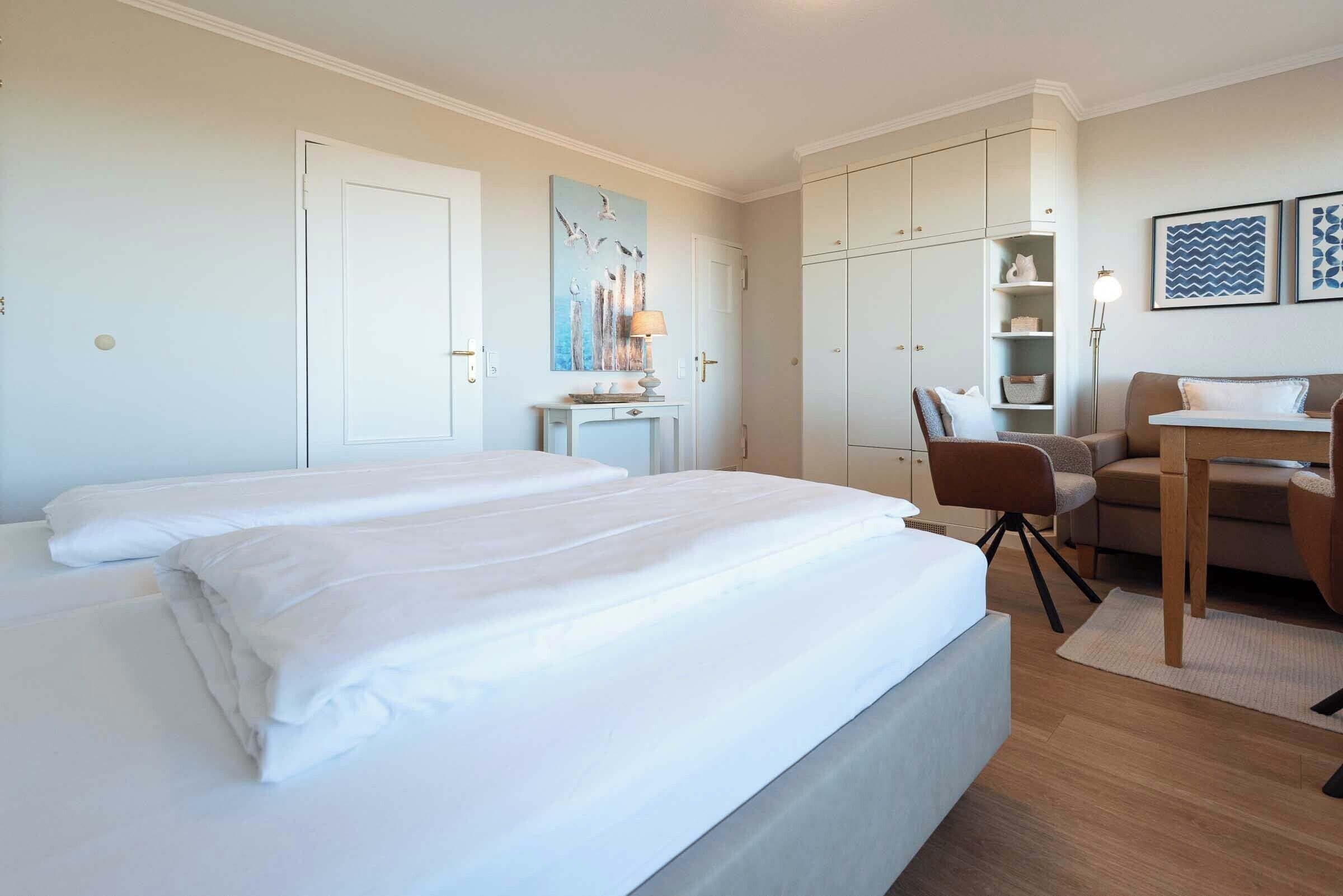 Een hotelkamer met een groot bed, een bureau, een stoel en een kledingkast.