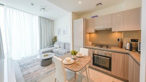 A modern apartment with a dining area, kitchen, and living space. - Yogi - Bright Apartment With Panoramic CityScape Views (Dubai)