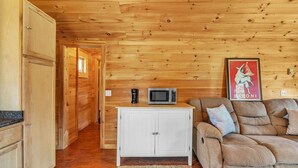 A wooden interior with a white cabinet, a sofa, and a framed picture on the wall. - Seawall Retreat! Close to Ocean & Acadia! (Southwest Harbor)