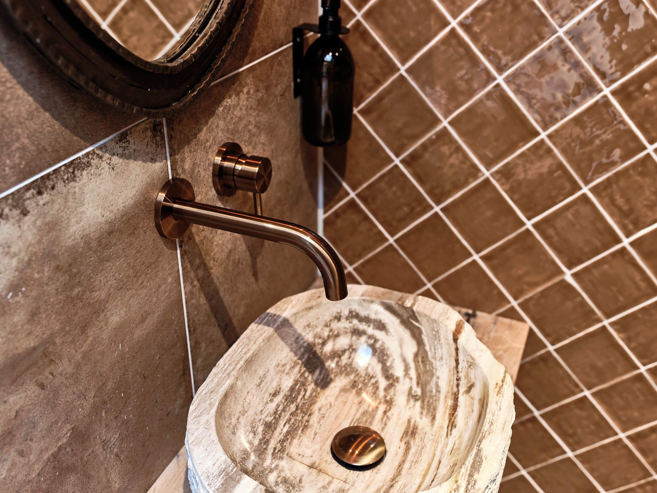 Une salle de bain avec un lavabo en marbre, une barre d’appui et un miroir.