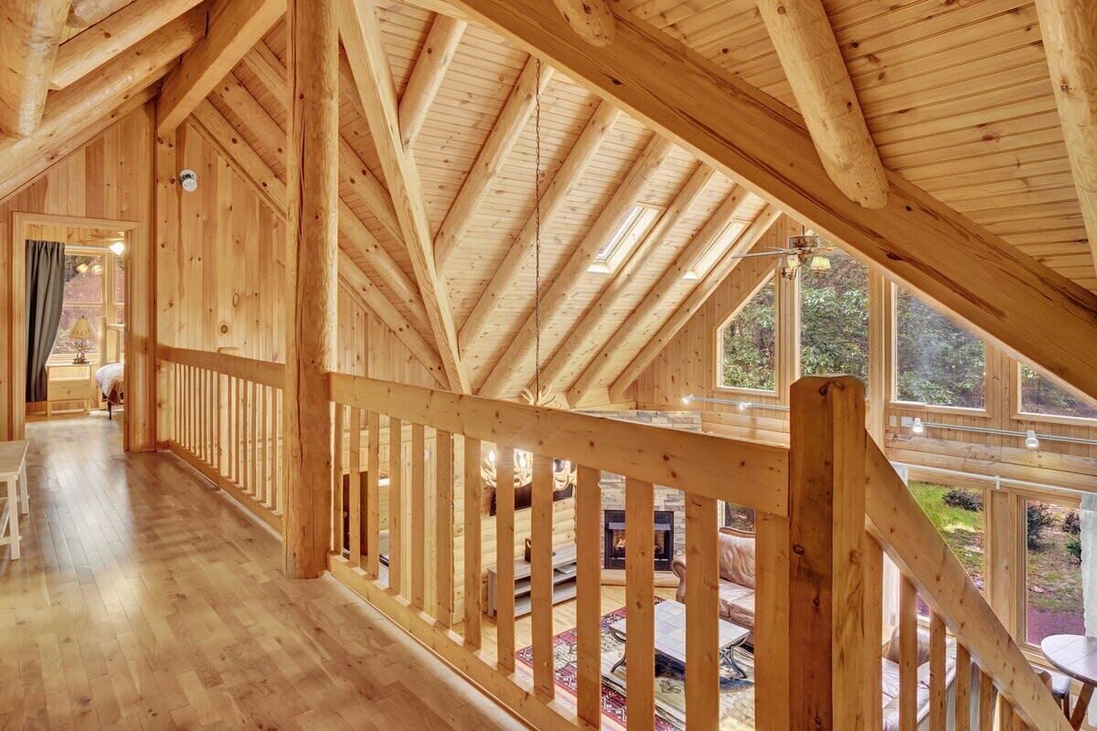 Een ruim houten interieur met een hoge plafond en grote ramen.