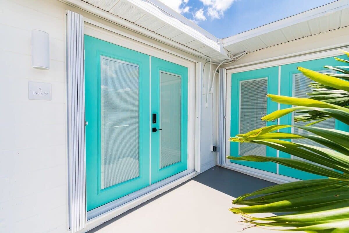 A building with turquoise doors and a white exterior.