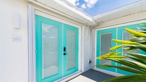 A building with turquoise doors and a white exterior. - The Juni-7 Unit Renovated Complex (Cocoa Beach)