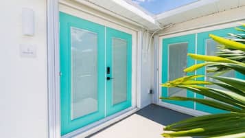 A building with turquoise doors and a white exterior.