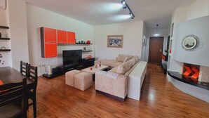 Ein modernes Wohnzimmer mit einer Couch, Fernseher und Holzböden.