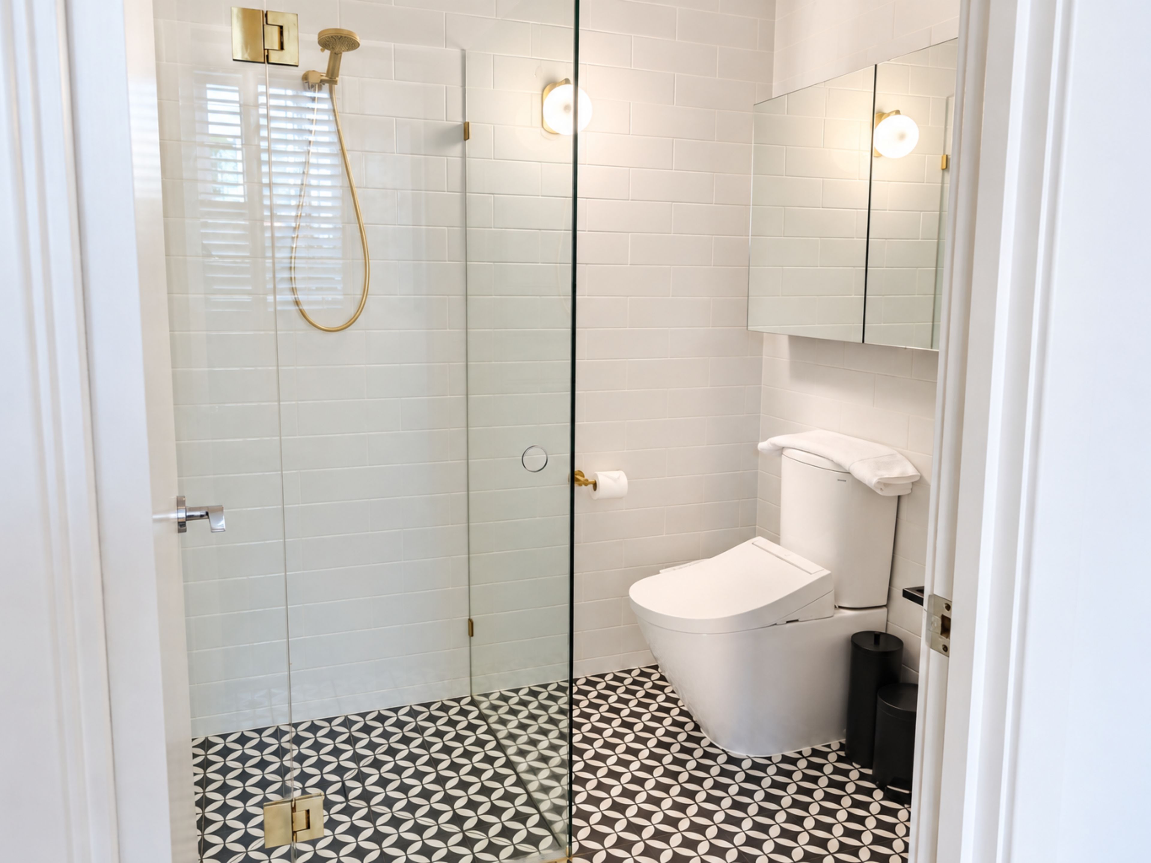 Un bagno moderno con box doccia in vetro, un water e un lavabo.