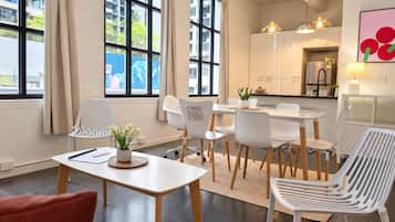 A modern interior with a dining area, kitchen, and large windows.