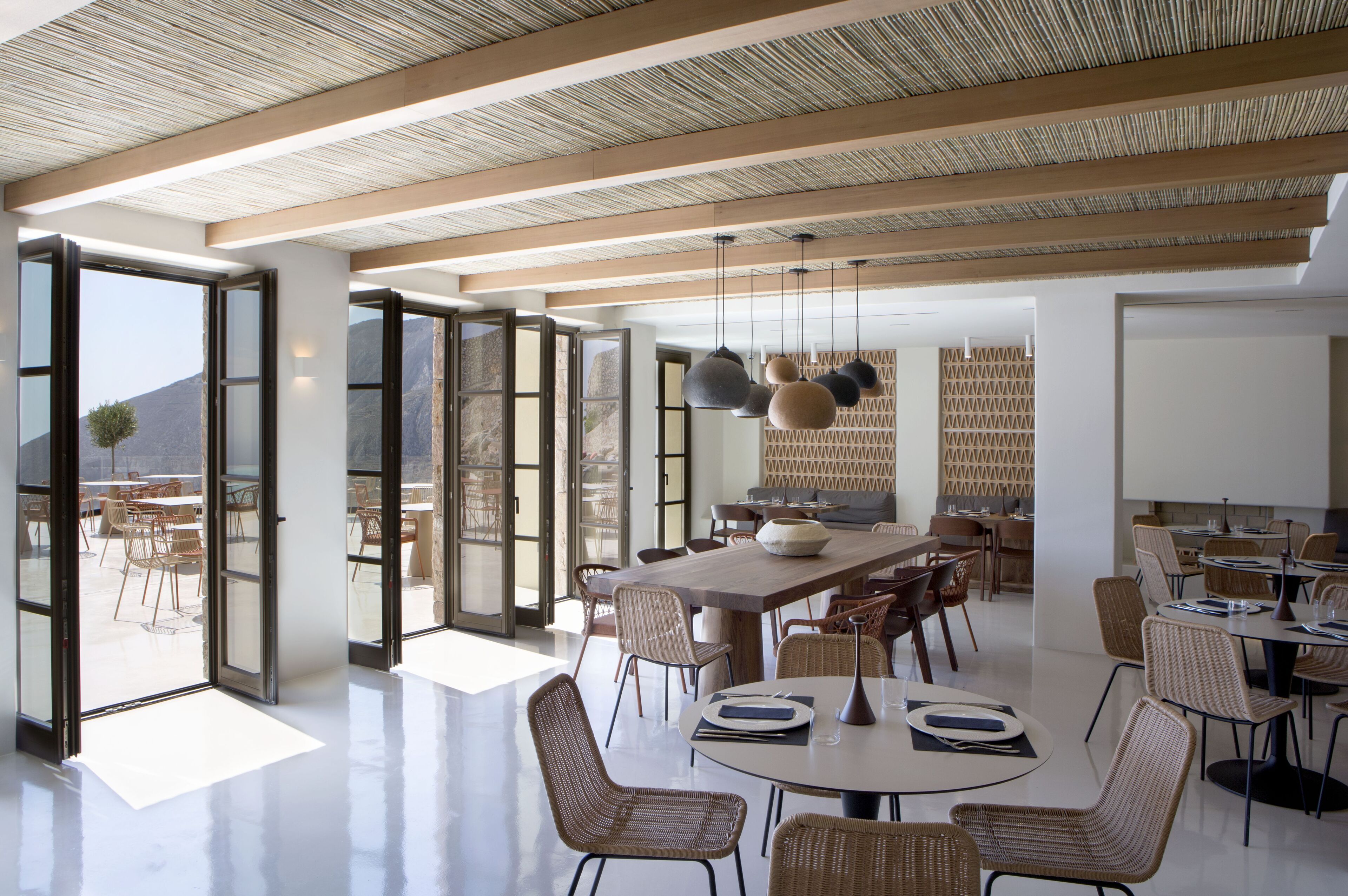Un comedor espacioso con techos altos, ventanas grandes y muebles modernos.
