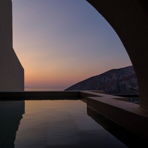 Ein Pool mit Blick auf eine Berglandschaft im Abendrot.