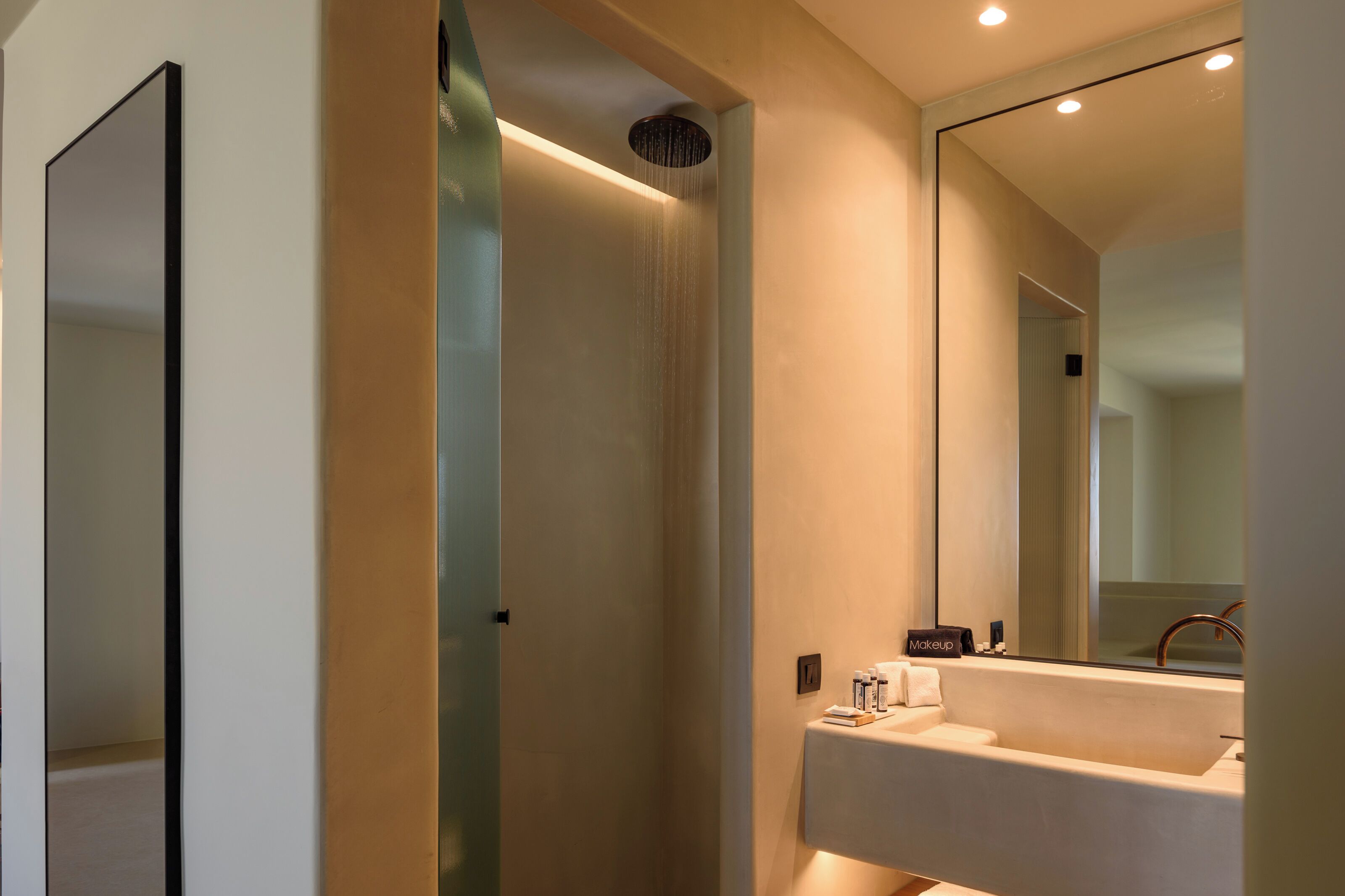 A modern bathroom with a large mirror, a bathtub, and a shower.