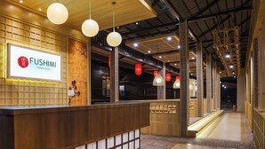 A restaurant interior with a reception desk, hanging lights, and traditional decor. - The Onsen Hot Spring Resort (Batu)