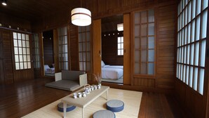 A traditional Japanese-style room with tatami flooring, a low table with tea set, and sliding doors with glass panels. - The Onsen Hot Spring Resort (Batu)
