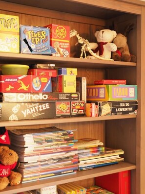 Una estantería con varios juegos de mesa y libros.