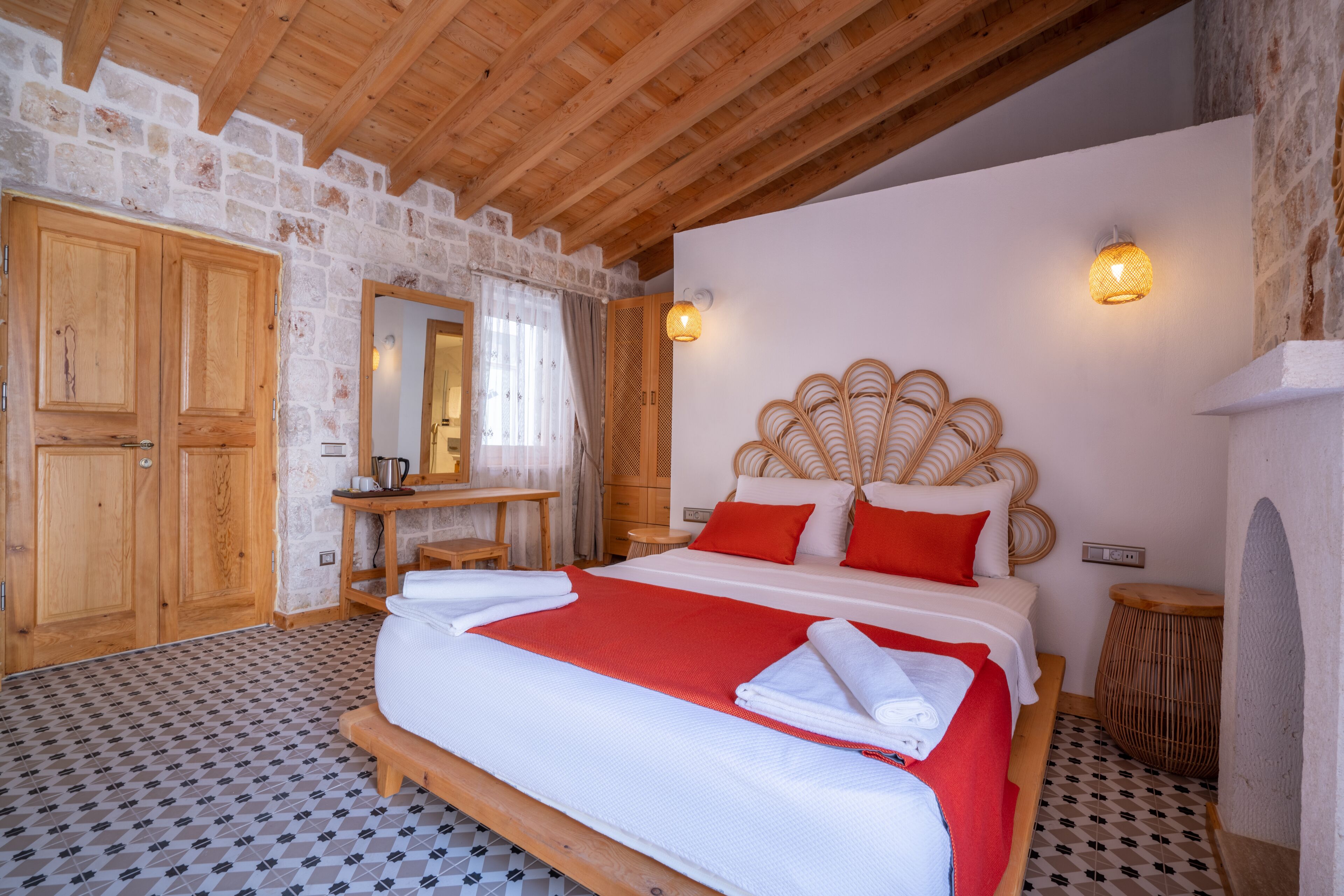 A bedroom with a wooden bed, a stone wall, and a wooden ceiling.