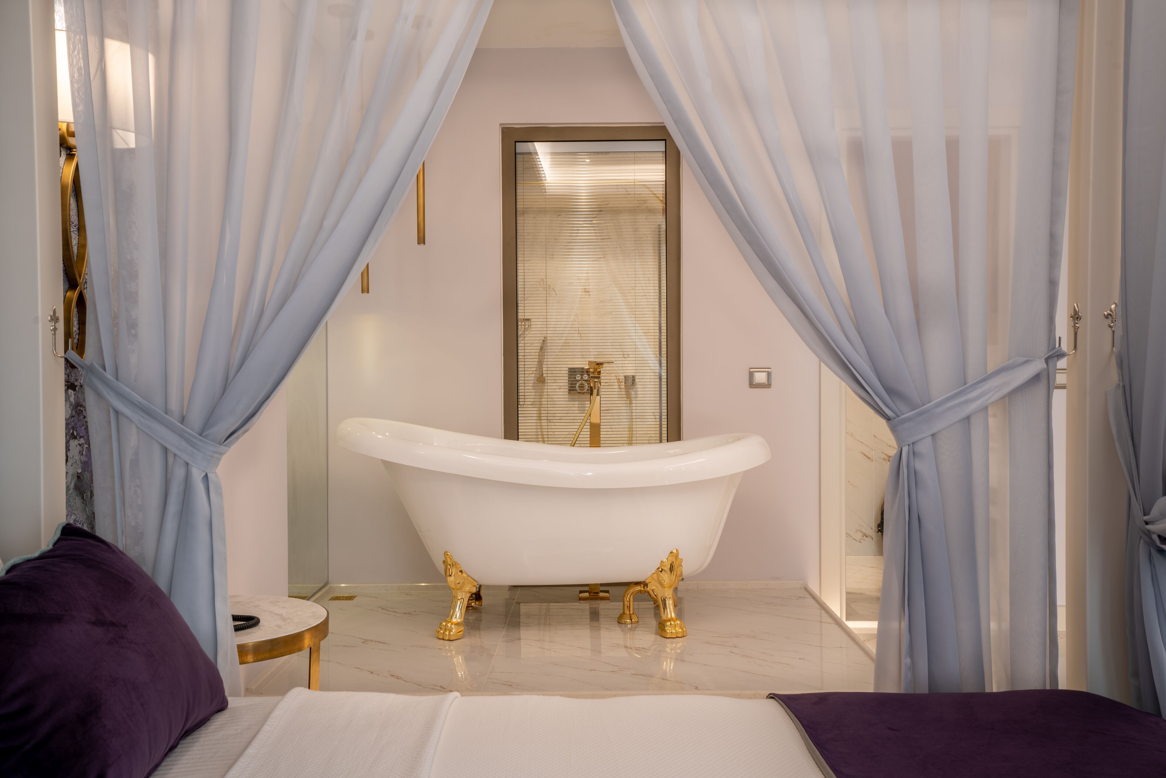 Un baño moderno con una bañera independiente, cabina de ducha de vidrio y suelo de mármol.