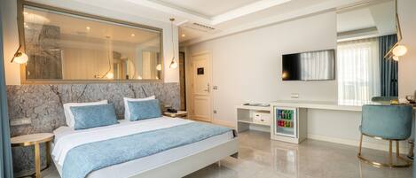 Un dormitorio moderno con una cama grande, un escritorio y un televisor.