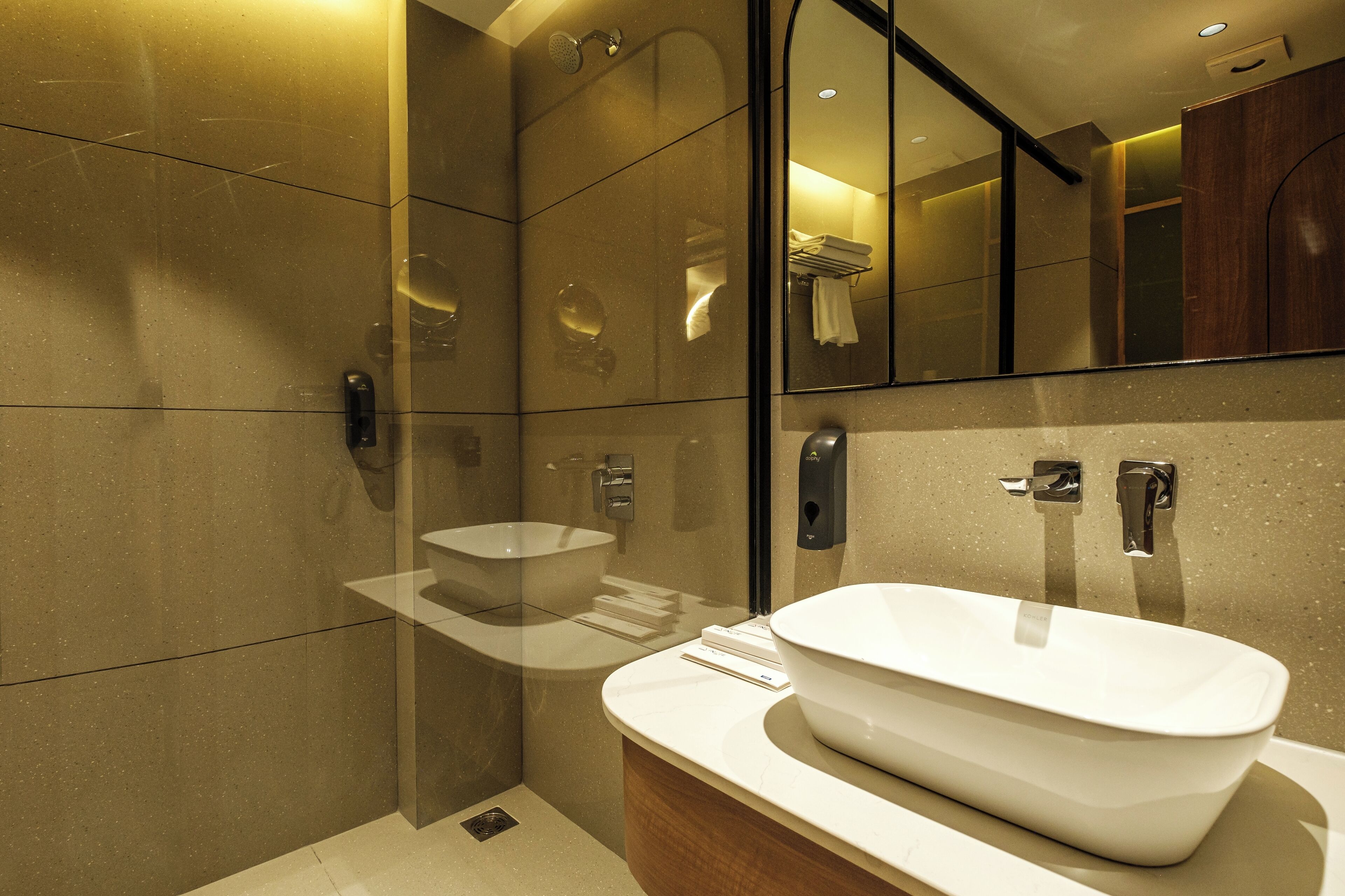A modern bathroom with a large mirror, a white sink, and a shower area.