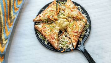 A black skillet with triangular food items on a white surface.
