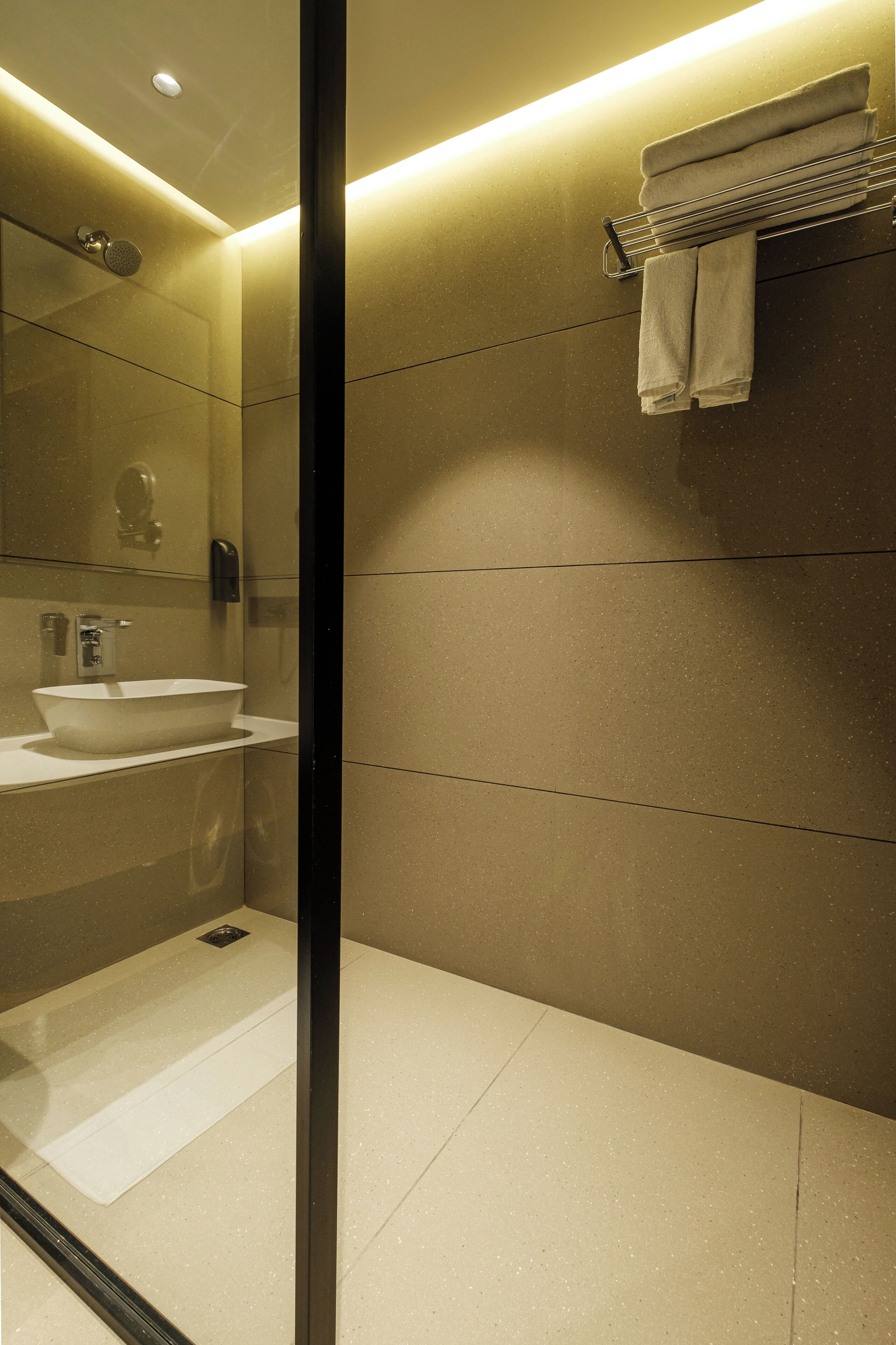 Een moderne badkamer met een grote spiegel, een wastafel en een handdoekrek.