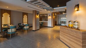 A modern hotel lobby with a reception desk, seating area, and a kitchen in the background. - Ewaa Express Hotel-Al Shati (Jeddah)