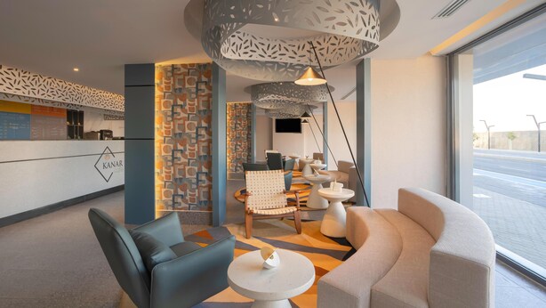A modern hotel lobby with a reception desk, seating area, and large windows. - Ewaa Express Hotel-Al Shati (Jeddah)
