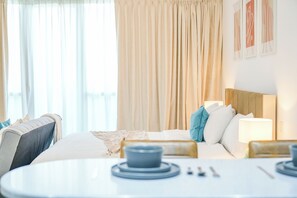 Comfort Studio | Living area | 50-inch Smart TV with cable channels, Netflix, streaming services -  Yogi - Serene Romance in a Stylish Studio with City Views (Dubai)