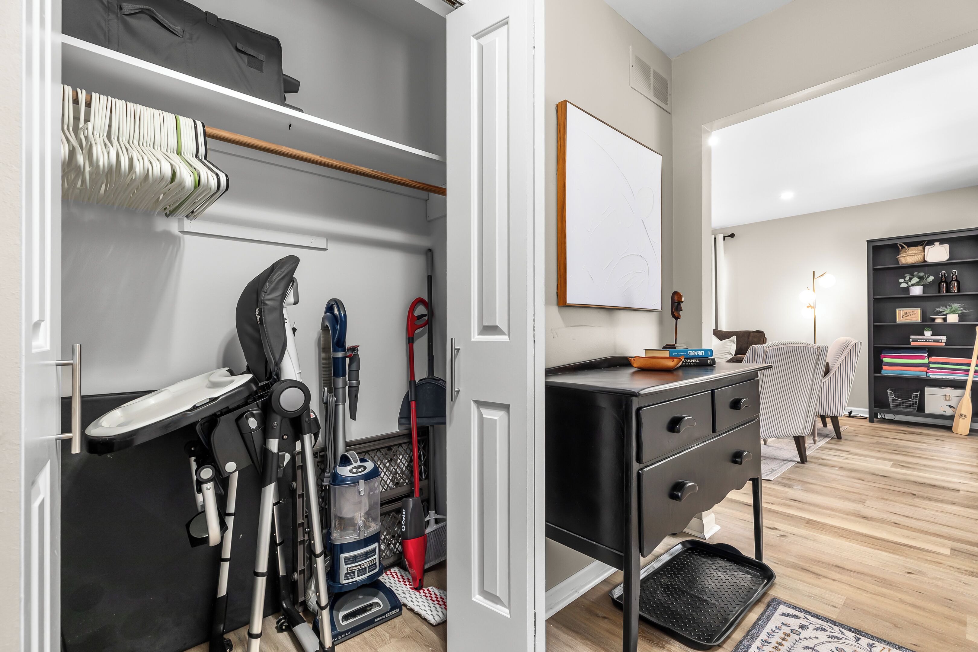 Ein aufgeräumter Raum mit Kleiderschrank, Schreibtisch mit Schubladen, einer Whiteboard-Tafel und einem Bücherregal.