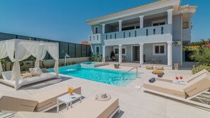 A rooftop pool area with lounge chairs, a canopy, and a two-story building in the background. - Fratelli Villa, with Heated Pool & Spa Whirlpool  (Zakynthos)