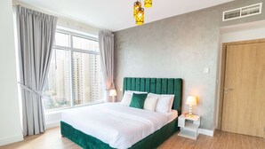 Een moderne hotelkamer met een groot bed, uitzicht op de stad en een houten deur.