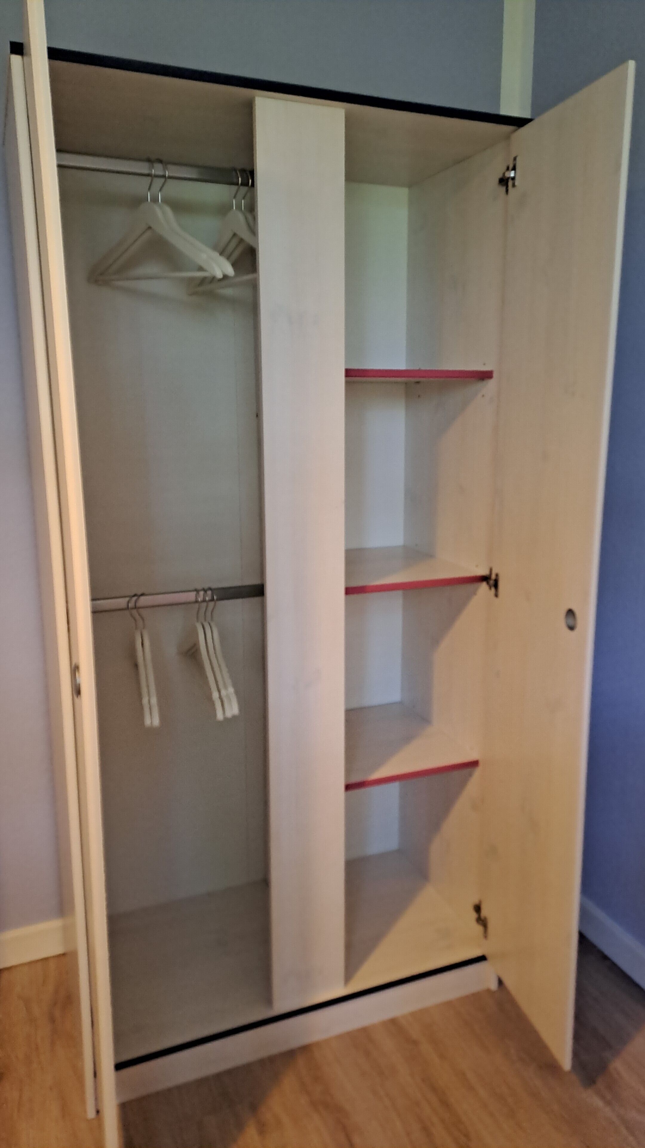 A wooden wardrobe with a sliding door, three shelves, and a hanging rod.