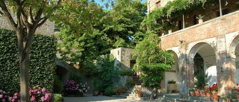 A courtyard with a stone bridge, arches, and potted plants.