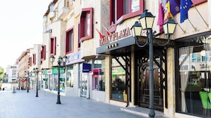 Une rue bordée de boutiques, parmi lesquelles se trouve un hôtel appelé « DAILY PLAZA HOTEL & RESTAURANT ».