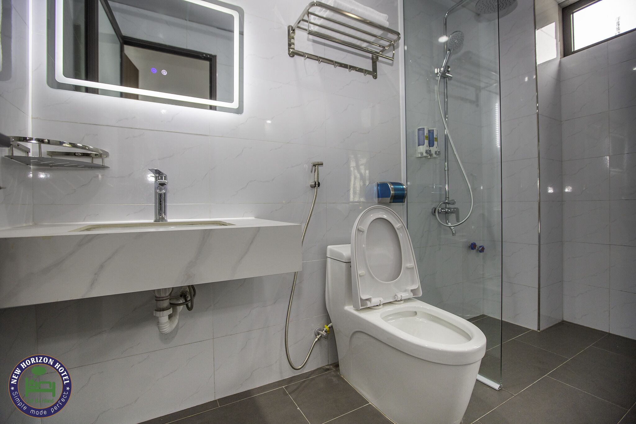 Un baño moderno con inodoro, lavamanos y ducha.