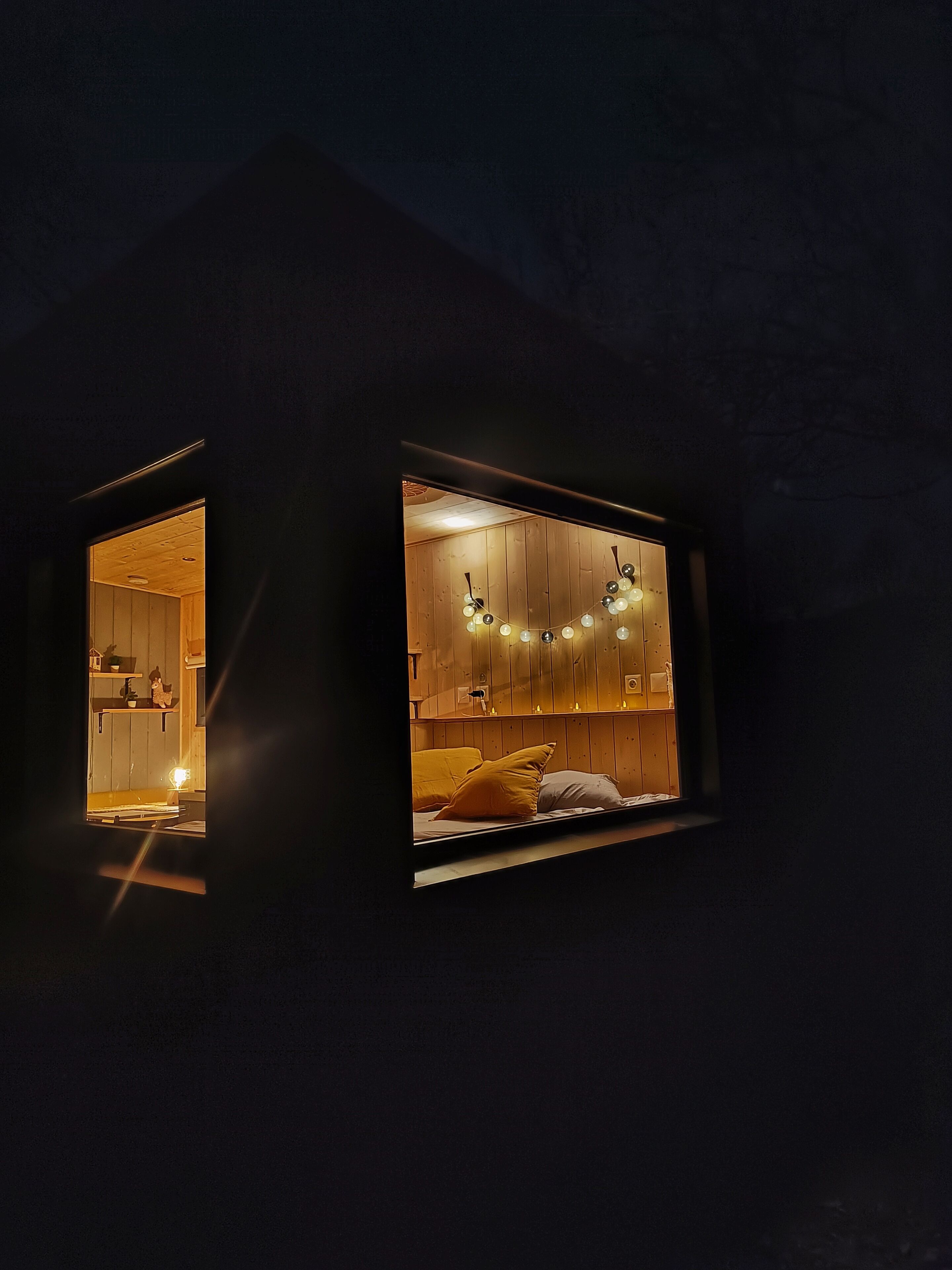 Una habitación con cama, ventana y techo de madera.
