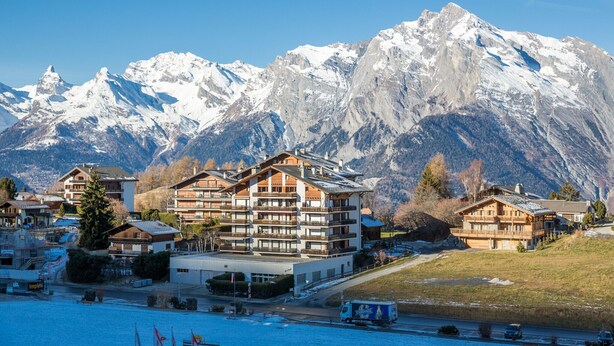 A mountain resort with multiple chalet-style buildings, a ski lift, and snow-covered peaks in the background. - Ecluses 6 - Nendaz centre & close to ski lift (Haute-Nendaz)