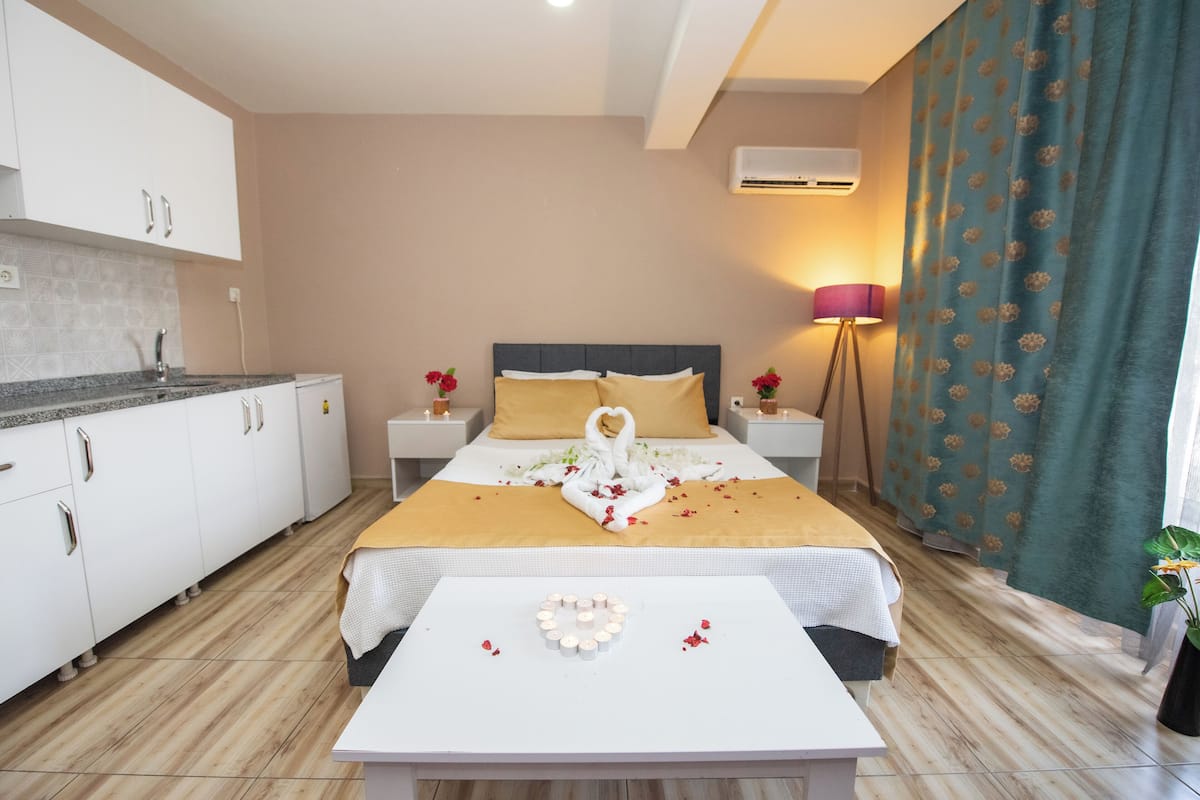 Une chambre d’hôtel avec un lit, une table de chevet, une lampe et une vue sur l’extérieur.