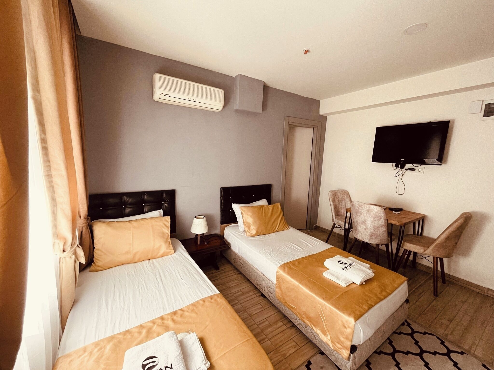 Een hotelkamer met twee bedden, een televisie, een bureau en een stoel.