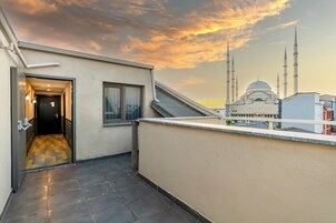 Un pasillo con vista a una mezquita con múltiples minaretes y una cúpula.