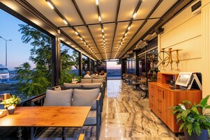Un interior moderno con una amplia zona de comedor, asientos y una recepción.