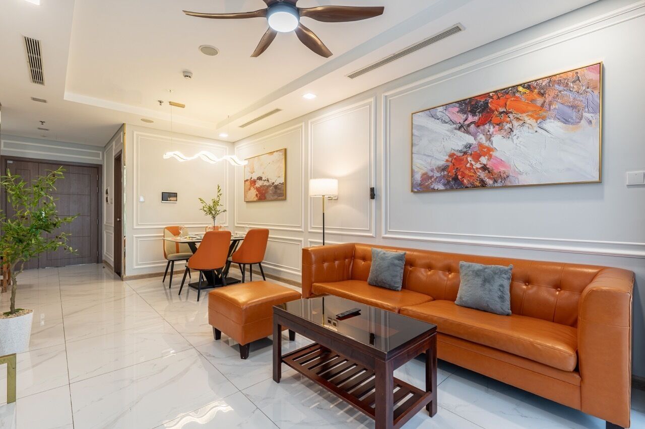 Un hall d’hôtel moderne avec un canapé en cuir, un coin repas et un ventilateur de plafond.