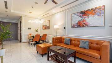 Un hall d’hôtel moderne avec un canapé en cuir, un coin repas et un ventilateur de plafond.