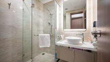 Un bagno moderno con doccia vetrata, lavandino bianco e uno specchio grande.