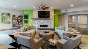 A modern living room with a stone fireplace, two sofas, a coffee table, and a bookshelf. - Hip & Vibrant 2 Bedroom Apartment with Parking & Wifi (Durham)