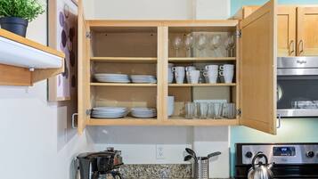A kitchen with wooden cabinets, a stove, and a coffee maker.