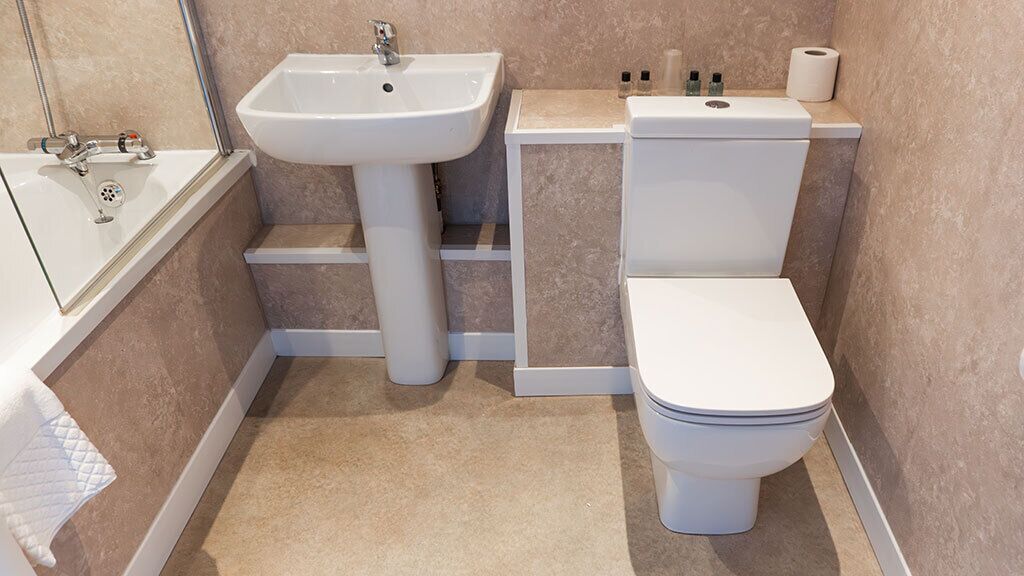 A bathroom with a sink, toilet, and bathtub.