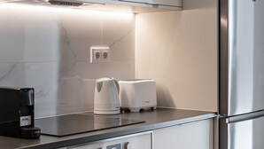 Eine moderne Küche mit Edelstahlgeräten, einem eingebauten Backofen und einer Kaffeemaschine auf der Arbeitsplatte.